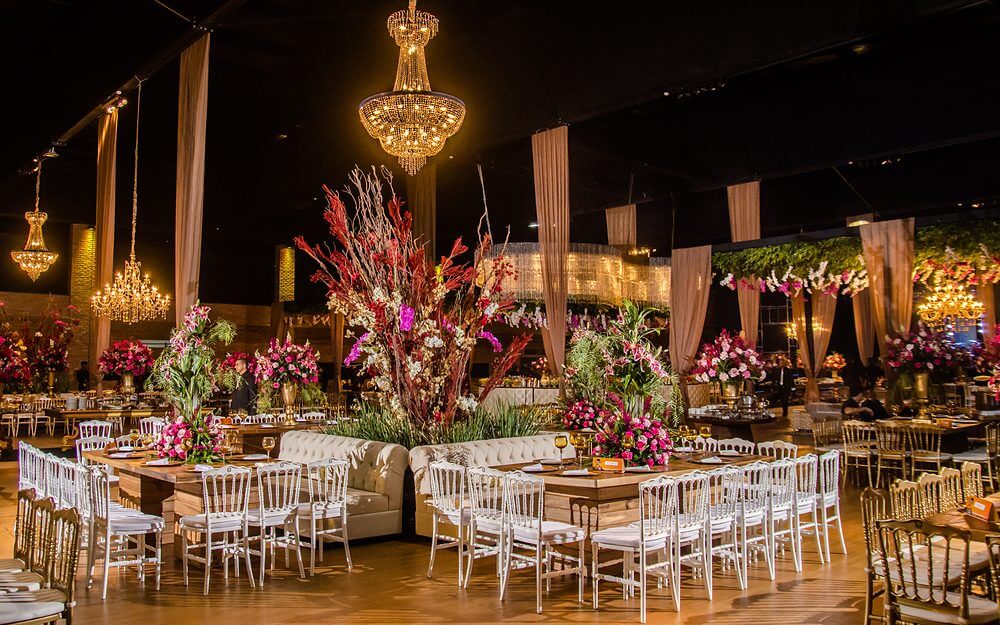 Salão do jantar de formatura em Belo Horizonte, com mesas postas e decoração de flores