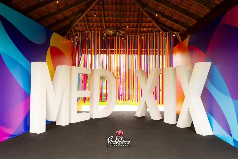 Cenografia personalizada com letras gigantes MED XIX em painel colorido