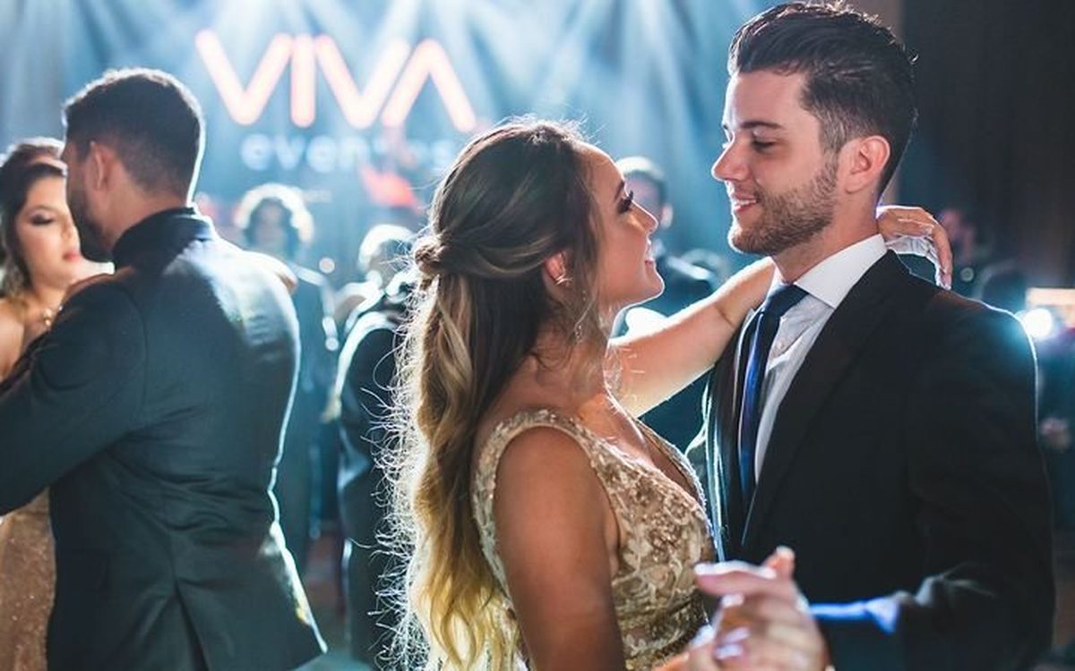 Baile de formatura da VIVA Eventos: casal de formandos dançando sob o letreiro VIVA