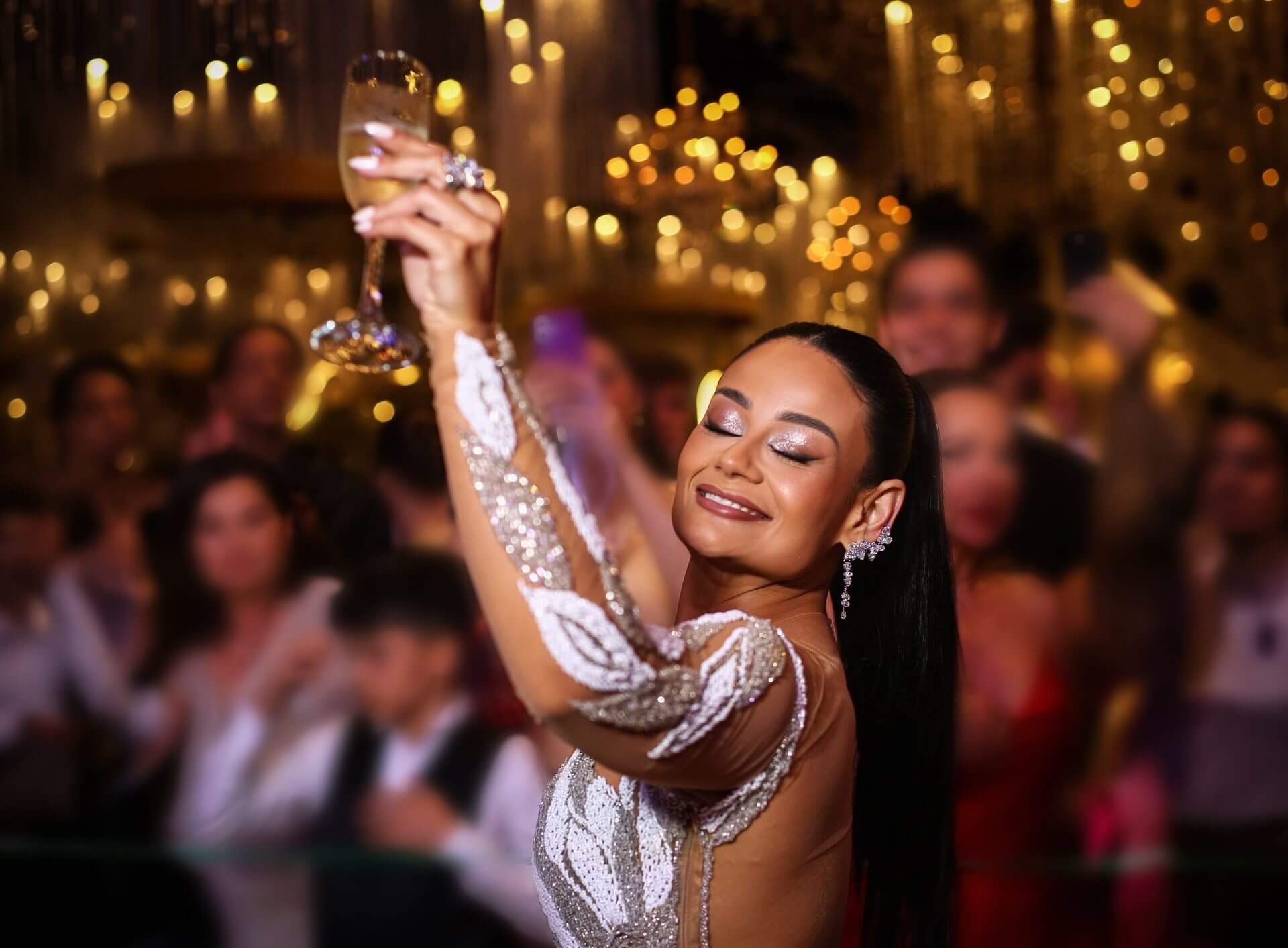 Formanda brindando com taça durante o baile de formatura da VIVA